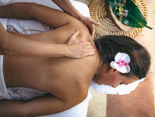 een vrouw met een bloem op haar rug die een massage krijgt bij Terrasse Hotel Playa del Carmen in Playa del Carmen