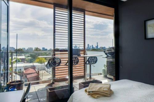 Schlafzimmer mit einem großen Fenster mit Blick auf das Wasser in der Unterkunft UPTOWN City Views in the Heart of South Yarra in Melbourne