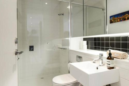 ein Bad mit einer Dusche, einem Waschbecken und einem WC in der Unterkunft UPTOWN City Views in the Heart of South Yarra in Melbourne
