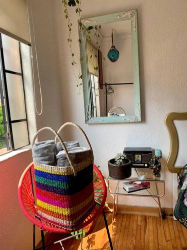 a basket on a chair in a room with a mirror at Lovely cozy & spacious room in heart of Condesa in Mexico City