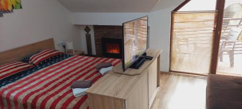 a bedroom with a bed with a television on a dresser at Apartment Invictus Mavrovo in Mavrovo