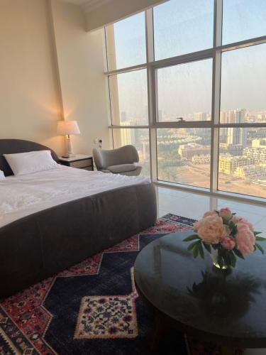 Un dormitorio con una cama y una mesa con flores. en Reef Residence en Dubái