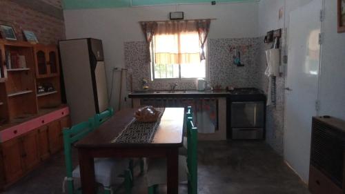 a kitchen with a wooden table and a refrigerator at Casita Ukuchay Pcia Bs As in General Belgrano