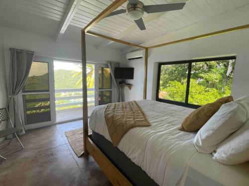 - une chambre avec un lit et une grande fenêtre dans l'établissement Amazing mountain top villa, à Marigot