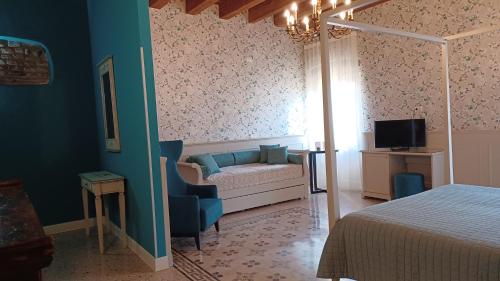 a bedroom with a bed and a chair and a television at All'Opera Prima in Verona