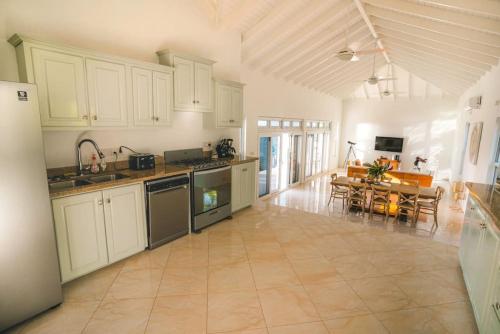 a large kitchen with white cabinets and a dining room at Amazing mountain top home with stunning views in Marigot