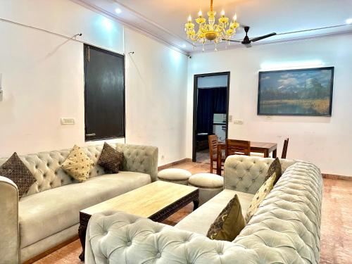 a living room with couches and a table at spacious 4 bhk with hall and kitchen near Medanta in Gurgaon