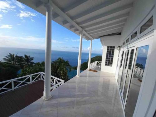 a balcony with a view of the ocean at Amazing mountain top home with pool in Marigot Bay