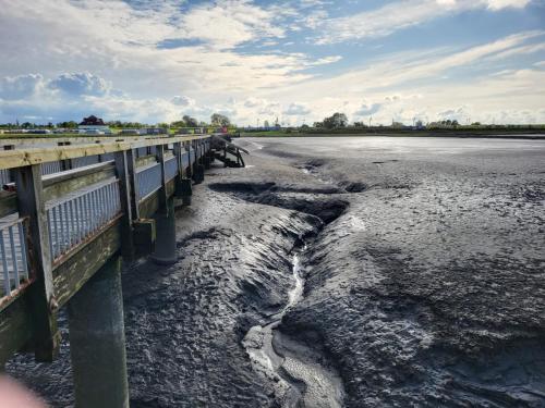 a bridge over a body of water next to a river at Wolkenlos in Butjadingen