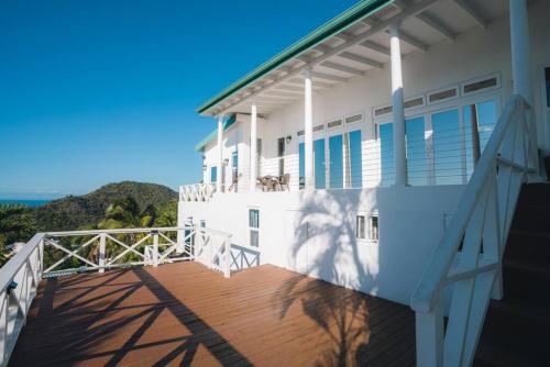 a balcony of a house with a view of the ocean at Amazing mountain top home with pool in Marigot Bay