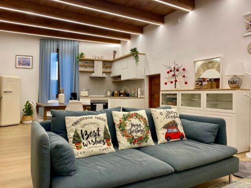 eine blaue Couch in einem Wohnzimmer mit Weihnachtskissen in der Unterkunft All’ombra del campanile in Tarquinia