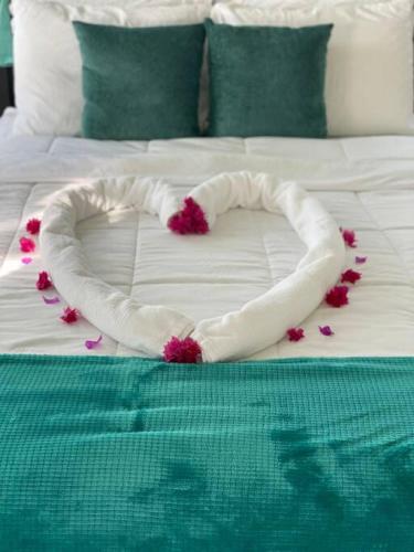 a bed with a heart made out of flowers on it at Amazing mountain top home with pool in Marigot Bay