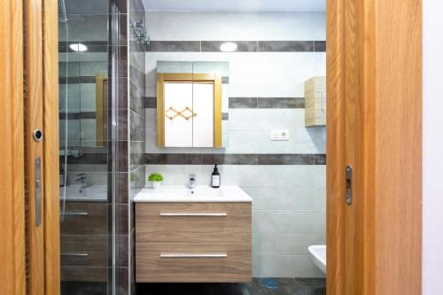 a bathroom with a sink and a mirror at Grace Apartments - 3 bedroom City Centre in Granada