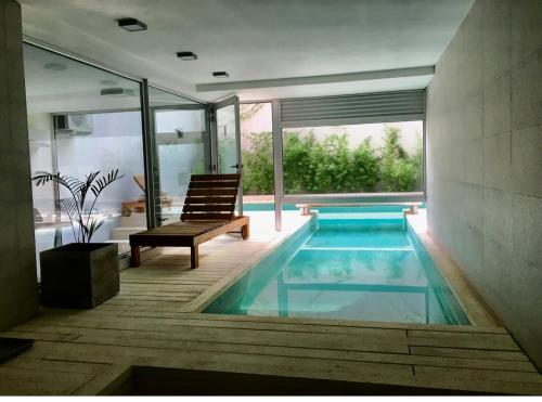 a swimming pool in a house with a bench and a chair at Studio Libertador Premium! Location ! in Buenos Aires
