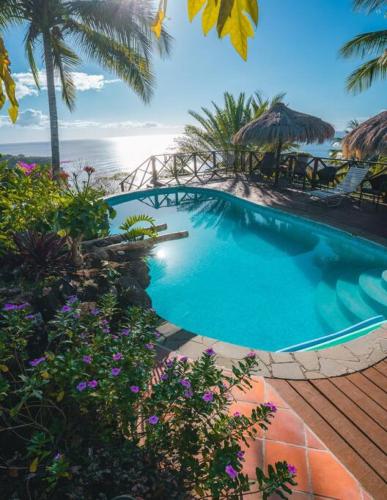 a swimming pool with a view of the beach at Amazing mountain top home with pool in Marigot Bay
