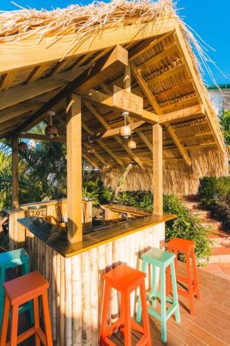 a bar with four colorful stools on a deck at Amazing mountain top home with pool in Marigot Bay