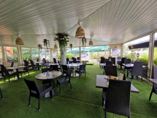 a dining room with tables and chairs and windows at BIVIUS Hotel Restaurant Luxembourg in Luxembourg