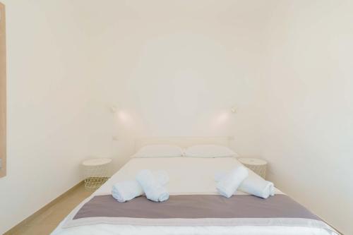 a white bedroom with a bed with two pillows at Guest House Deidda - TS ROOMS B&B in San Sperate