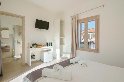 a white bedroom with a large bed and a window at TS ROOMS - Guest House Deidda in San Sperate
