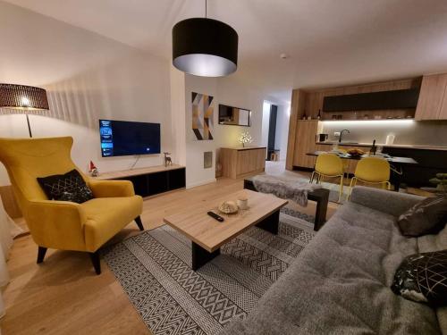 ein Wohnzimmer mit einem Sofa und einem Tisch in der Unterkunft Olimpijska kuca 202 in Jahorina