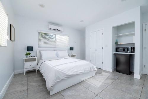 a white bedroom with a bed and a kitchen at Bayshore Breeze 10 in Fort Lauderdale