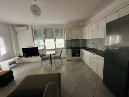 a kitchen with white cabinets and a table in it at Summer Holiday in Shëngjin