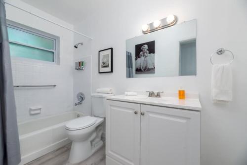 a white bathroom with a toilet and a sink at Short Walk to Wilton Drive Apt1 in Fort Lauderdale