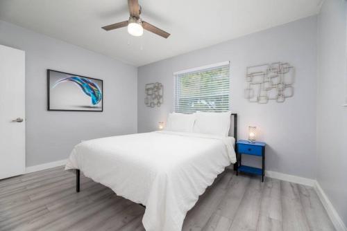 a white bedroom with a bed and a ceiling fan at Short Walk to Wilton Drive Apt1 in Fort Lauderdale