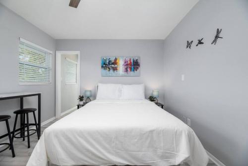 Un dormitorio blanco con una cama grande y una mesa en Short Walk to Wilton Drive Apt5, en Fort Lauderdale