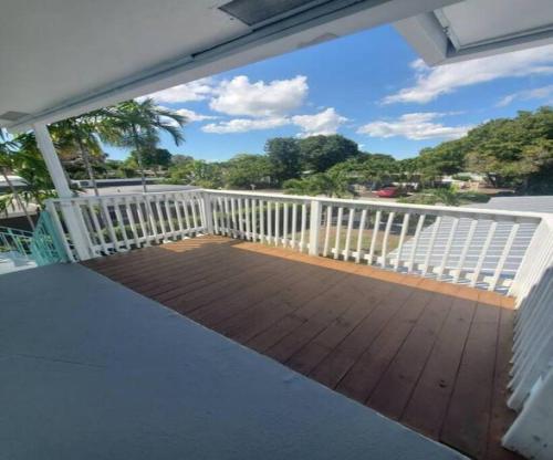 a balcony with a wooden floor and a white railing at Short Walk to Wilton Drive Apt4 in Fort Lauderdale