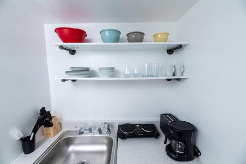 um lavatório de cozinha com pratos e tigelas nas prateleiras em Short Walk to Wilton Drive Apt6 em Fort Lauderdale