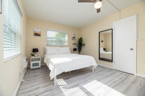 um quarto com uma cama branca e um espelho em Short Walk to Wilton Drive Apt6 em Fort Lauderdale