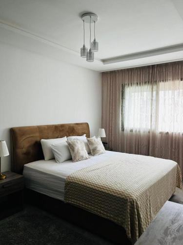 a bedroom with a large bed with pillows at Harhoura Modern Flat in Temara
