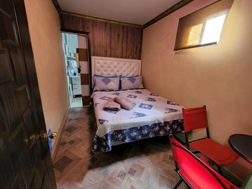 Hotel La Pampa في Alto Hospicio: غرفة نوم صغيرة مع سرير في غرفة