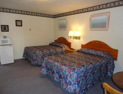 a hotel room with two beds and a table at Theater Motel in Westfield