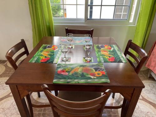 a wooden table with wine glasses on top of it at Veronica Homestay Lucea Jamaica in Lucea
