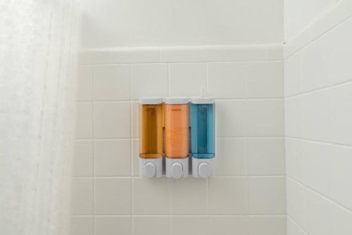 a white tiled wall with four different colored bottles at Just Off Wilton Drive Apt 5 in Fort Lauderdale