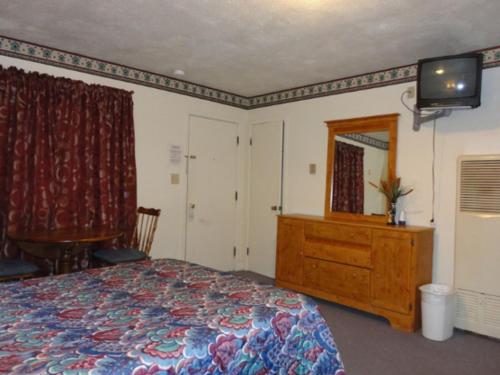 a bedroom with a bed and a dresser and a mirror at Theater Motel in Westfield