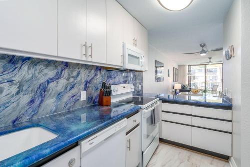 uma cozinha com armários brancos e bancadas de mármore azul em Kanai a Nalu 314 - Newly Renovated, Oceanfront, AC em Wailuku