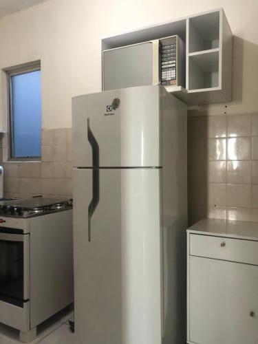 a kitchen with a refrigerator and a microwave at Edifício Malibú in Praia Grande