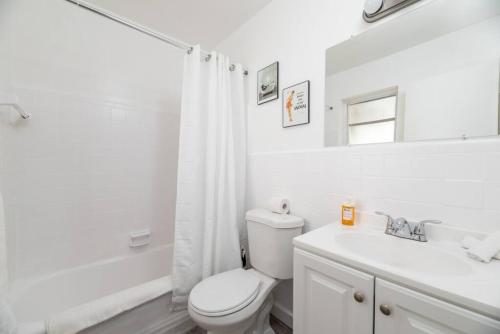 Un baño blanco con inodoro y lavabo. en Just Off Wilton Drive Apt 8, en Fort Lauderdale