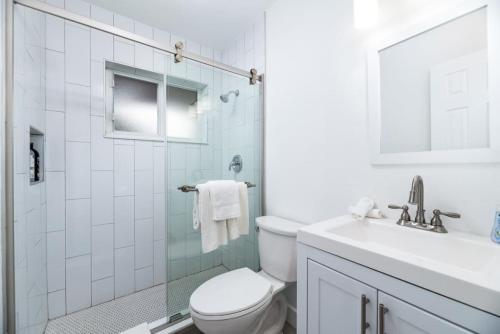 a white bathroom with a toilet and a sink at Comfy Condos at Middle River Apt 2 in Fort Lauderdale