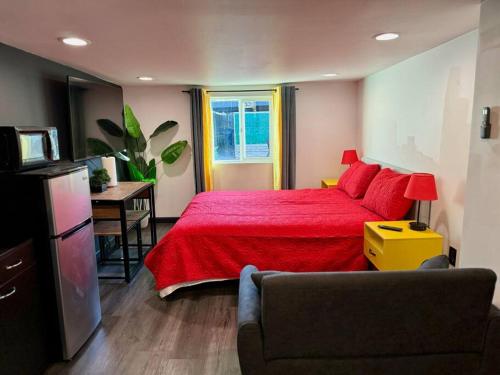 1 dormitorio con cama roja y TV en New Tiny Home Uptown Phoenix (Unit E), en Phoenix