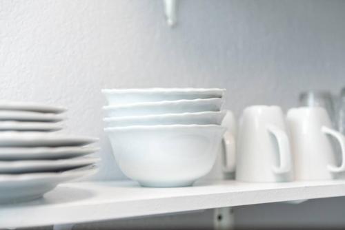 a shelf with white bowls and plates on it at The Dolphin Studio at Lake Ridge in Fort Lauderdale