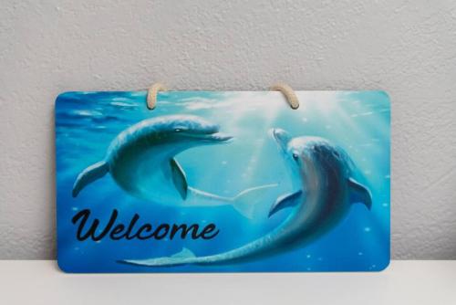 a welcome sign with two dolphins swimming in the water at The Dolphin Studio at Lake Ridge in Fort Lauderdale
