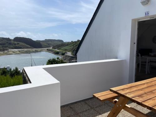 d'un balcon avec une table et une vue sur la rivière. dans l'établissement Appartement T2 vue mer Sauzon terrasse et parking privés, à Sauzon