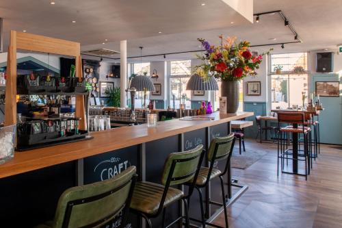 a bar at a restaurant with green chairs at De Watersport Heeg in Heeg