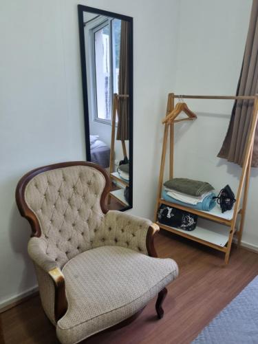 ein Wohnzimmer mit einem Stuhl und einem Spiegel in der Unterkunft Apartamento aconchegante em Copacabana - unid 1016 in Rio de Janeiro