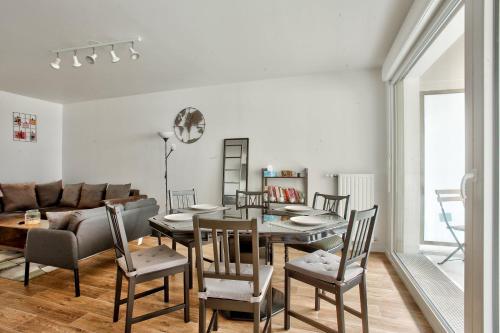 un salon avec une table, des chaises et un canapé dans l'établissement Chambre privée dans un appartement en colocation, parking gratuit, à Bagneux