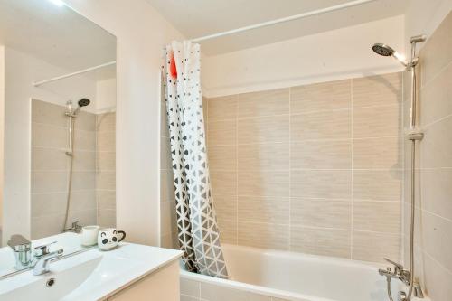 a bathroom with a tub and a sink and a shower at Grand apart Bagneux in Bagneux